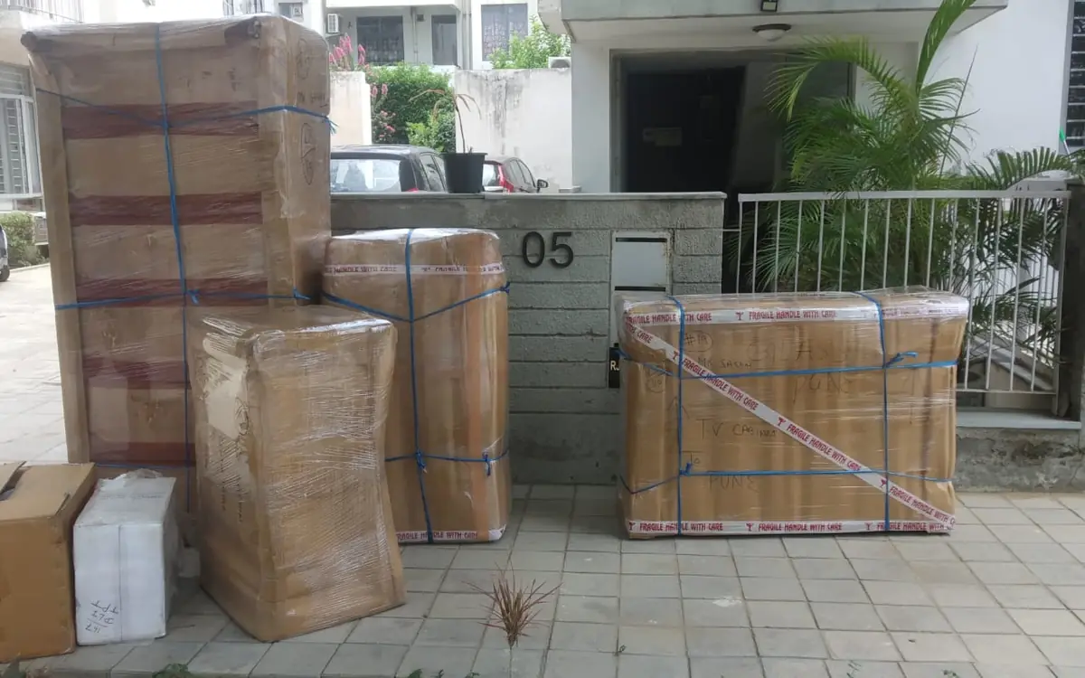 Cartons and wrapped furniture packed and ready outside a house